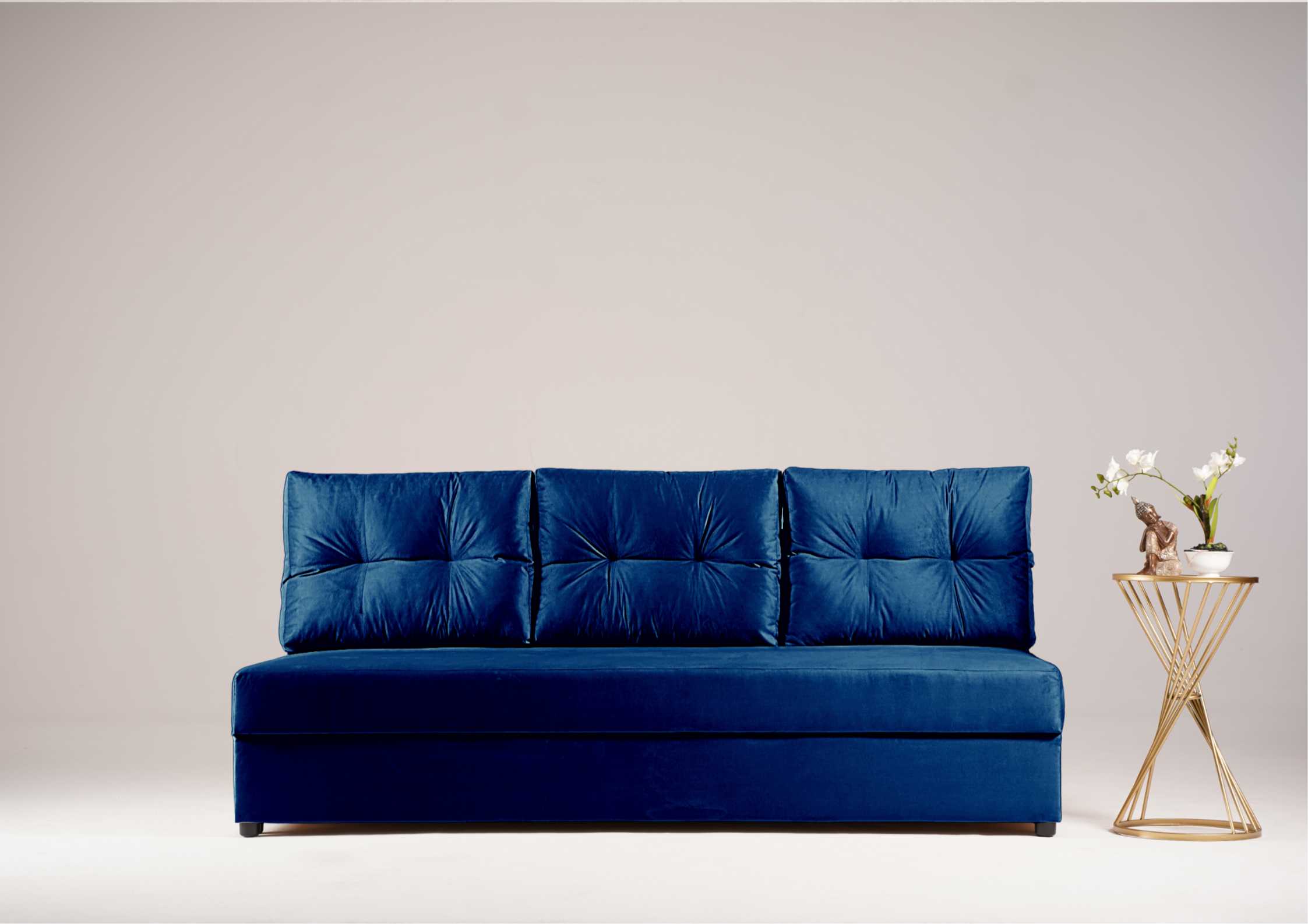 Granatowa sofa z pikowanymi poduszkami